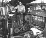 US Army Privates Mearl Hatfield and Clen C. Campbell operating the portable laundry diesel engine, New Guinea, 19 Apr 1943