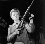 Female factory worker posed with finished Sten sub-machinegun, Small Arms, Ltd., Mississauga, Ontario, Canada, 26 May 1942