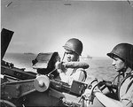 Two Ohio United States Coast Guard men, John R. Smith and Daniel J. Kaczorowski, at their gun aboard a transport off Normandy, circa Jun 1944