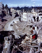 Two French boys watched from a hilltop as Allied vehicles passed through the badly damaged city of Saint-Lô, France, circa Jul-Aug 1944