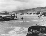 Scene on Omaha Beach in Normandy, 6 Jun 1944; note LCI(L)-553 in background and a LCVP from APA Samuel Chase in left center