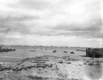 DUKW amphibious trucks of the 470th Amphibious Truck Company, First Engineer Brigade, bringing supplies to Utah Beach from ships anchored off shore, Normandy, 8 Jun 1944; note German gun in foreground