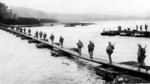 US Army soldiers crossing the Machinato Inlet on foot bridge, Okinawa, Japan, morning of 19 Apr 1945