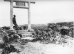 US Marine code talker Samnuel Sandoval of III Amphibious Corps Signal Battalion underneath a Torii gate on Okinawa, Japan, 1945