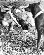 US Marine Private First Class Fred Muscard cleaning himself while his war dog Lux stood on guard, Okinawa, Japan, Apr 1945