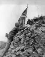 US Marine Lieutenant Colonel R. P. Ross, Jr. raising an US flag over Shuri castle on Okinawa, Japan, 29 May 1945, photo 1 of 2