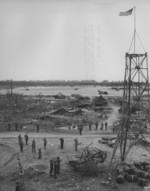 The first formal raising the American flag over Peleliu, Palau Islands, 27 Sep 1944; note Japanese observation tower