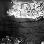 Aerial view of Naval Air Station Ford Island, Oahu, US Territory of Hawaii, 10 Dec 1941; note damaged PBY aircraft, USS Curtiss, and USS Shaw