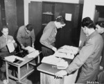 US Army Lieutenant A. H. Hadden and his staff working on passes issued to participants of the Potsdam Conference, Germany, 14 Jul 1945