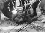 Polish insurgent fighter surrendered from his position in the sewers under Warsaw, Poland, 27 Sep 1944, photo 1 of 2; note MP 40 submachine gun