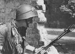 Polish resistance fighter with K pattern flamethrower and wz.31 helmet near the Mała Pasta building, Warsaw, Poland, 22 Aug 1944