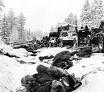 Column of Russian vehicles driving by dead Russian soldiers, Battle of Raate Road, Jan 1940