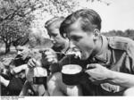 Hitler Youth members eating a meal while on a field exercise, date unknown