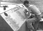 Staff Sergeant Marvin Culbreth of 13th Bomb Squadron of USAAF 3rd Bomb Group lettering a memorial to fallen comrades at an airfield at Port Moresby, Australian Papua, 1943