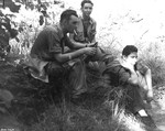 USAAF 3rd Bomb Group personnel L. B. Cook, Marvin Culbreth, and Jack Heyn resting between Port Moresby and Rouna Falls, Australian Papua, early 1943