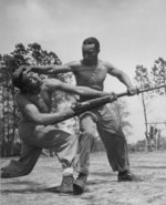 African-American US Marine Corps Corporal Arvin Lou Ghazlo giving judo instructions to Private Ernest C. Jones, Montford Point Camp, North Carolina, United States, Apr 1943; note M1 Garand rifle