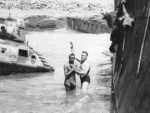 Regimental Chaplain John Craven of US 14th Marine Regiment performing a Christian baptism for a soldier of US 476th Amphibious Truck Company at Iwo Jima, Japan, 1945