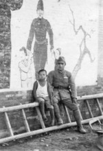 Japanese soldier with Chinese child, China, date unknown