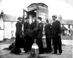 US Coast Guardsmen Joseph Andy, Casiano Aquino, Vincent G. Igoe, George Trigony, Carlton Lee, and Daniel Riley using a payphone Scotland, date unknown; note the mixing of ethnicities