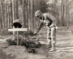 US soldier examining the grave of an unidentified American, who was buried by the Germans before US troops overran the German line, Europe, 1945