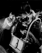 African-American factory workers working on the pilot compartment of an aircraft, United States, May 1942