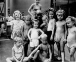 US Navy African-American cook Pendleton Thompson posed with children recently freed from a Japanese internment camp in the Philippine Islands aboard the SS Jean Lafitte en route for the US, Apr 1945