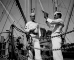 US Navy African-American Coxswain William Green checked his pistol while Quartermaster 1st Class Albert S. Herbert stood by with clip of ammunition and a holster belt, date unknown