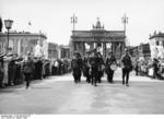 Uniformed German guards marching down Unter den Linden during the Summer Olympics in Berlin, Germany, Aug 1936; note Brandenburg Gate in background