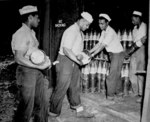 US Navy African-American Seamen 1st Class Dodson Samples, Raymond Wynn, Edward Clavo, and Jesse David loading 6-in shells in a magazine on Espiritu Santo, New Hebrides, date unknown