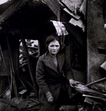 A British girl before a V2 rocket-damaged building, Battersea, London, England, United Kingdom, 27 Jan 1945