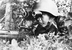 Soviet sniper Sergeant P. Dorzhiev posing in the field with binoculars, 1942