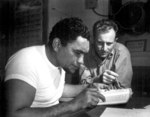 African-American US Merchant Marine Boatswain Maxie Weisbarth learning navigation from Chief Mate Earl Stanfield aboard a Victory Ship, Pacific Ocean, date unknown