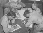 US personnel studying the map of a Japanese city, Saipan, Mariana Islands, 1945