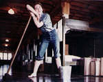 WAVES trainee leaning on a mop while cleaning her barracks at a Naval Training Center in the United States, circa early 1944