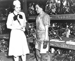 US Navy WAVES Captain Mildred McAfee listening to Storekeeper 2nd Class Dorothy Oates, Naval Air Station Pearl Harbor, US Territory of Hawaii, 4 Jul 1945