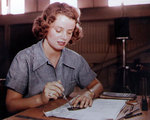 WAVES Aviation Metalsmith 2nd Class Elizabeth Holbrook checking a finished metal bracket against its blueprint in a repair building at a Naval Air Station in the Hawaiian islands, circa mid-1945