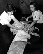 WAVES Parachute Riggers 3rd Class Pearl L. Pittelkow and Virginia Sibbald repacking a parachute, Naval Air Station, Memphis, Tennessee, United States, circa 1943, photo 1 of 2