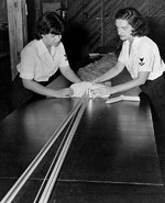 WAVES Parachute Riggers 3rd Class Pearl L. Pittelkow and Virginia Sibbald repacking a parachute, Naval Air Station, Memphis, Tennessee, United States, circa 1943, photo 2 of 2
