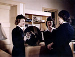 Yeoman 2nd Class Bernice Elliot and Yeoman 3rd Class Martha Dietlin watched as Seaman 1st Class Kay Magee tried on her Overseas Cap, Naval Air Station, New Orleans, Louisiana, United States, 1944-1945