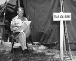 Rear Admiral Burke reading outside his tent at the United Nations