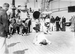 Ensign Burke pushing a peanut by blowing on it during a shipboard competition aboard USS Arizona, circa 1923-1925