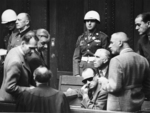 Heß, Seyß-Inquart, Frank, Papen, Frick, and Speer talking to each other, Nuremberg, Germany, 1945-1946; note Alfred Jodl and policeman Albert Rose in background