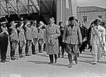 Adolf Hitler and Benito Mussolini walking in front of saluting military during Hitler