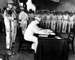 MacArthur signing Japanese surrender aboard USS Missouri, 2 Sep 1945, photo 1 of 4