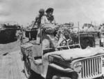 General Bernard Montgomery of UK 8th Army in Sicily, Italy, Jul or Aug 1943; note Willys MB and two GMC DUKW vehicles