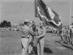 Major General Lewis Puller handing the US 2nd Marine Division flags to Brigadier General Edward Snedeker shortly after Puller took command of the division, Camp Lejeune, Jacksonville, North Carolina, United States, 1 Jul 1954
