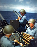 Crew of a 40mm quad anti-aircraft machine gun mount of Alaska loaded clips into the loaders of the left pair of guns, off Iwo Jima, 6 Mar 1945