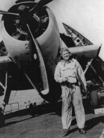 Lieutenant R. S. Evarts posing with a TBF Avenger aircraft aboard USS Coral Sea, 30 Oct 1943