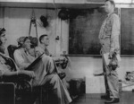 Lieutenant Commander J. J. Lynch conducting a pre-flight briefing aboard USS Coral Sea, 30 Oct 1943