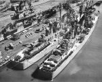 Boston and Canberra nested together during change of command ceremony (RAdm Martell relieved RAdm Melson, ComCruDiv4), Norfolk Naval Base, Virginia, US, 14 Apr 1958; note Intrepid in background